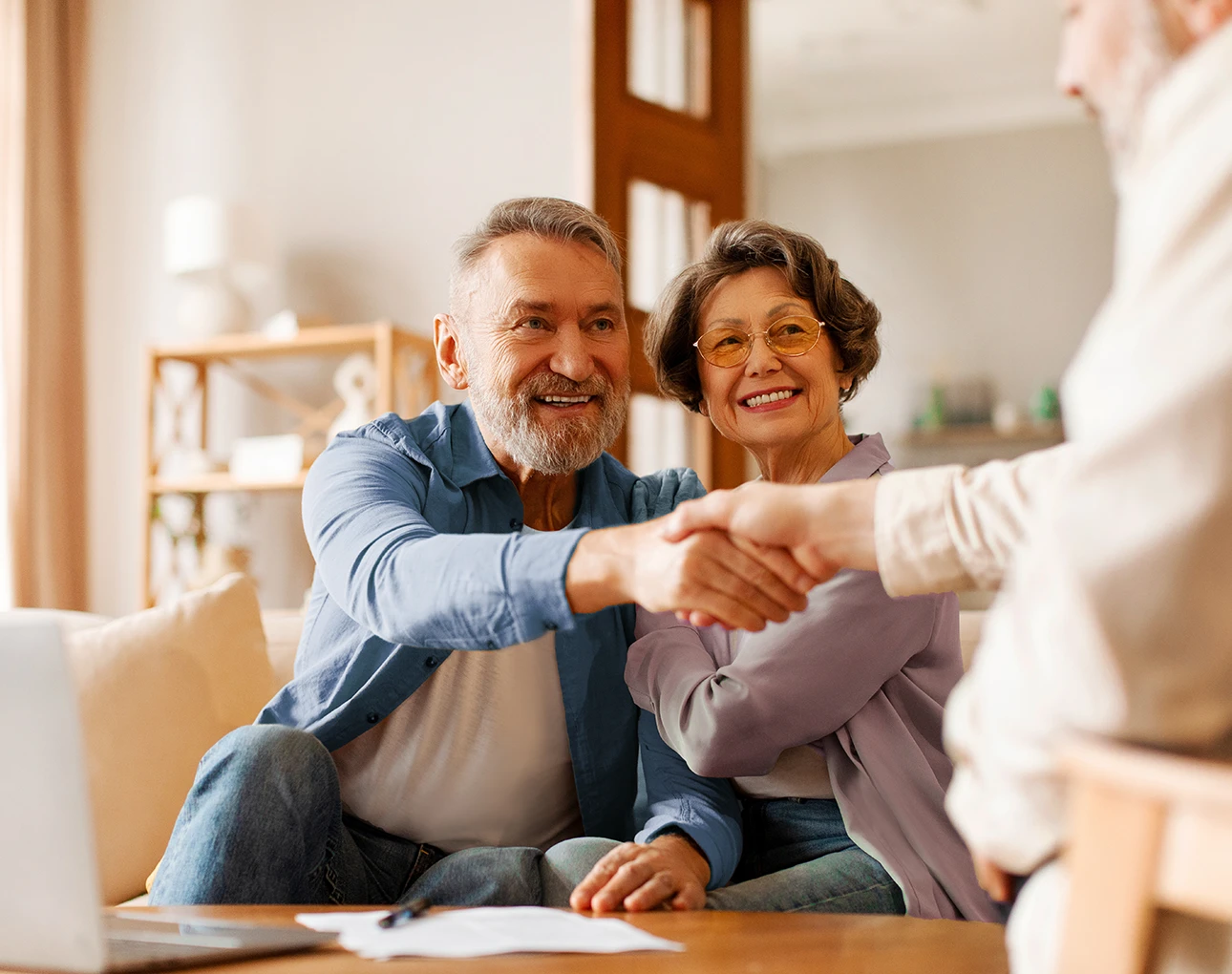 Happy couple shaking hands with a insurance agent